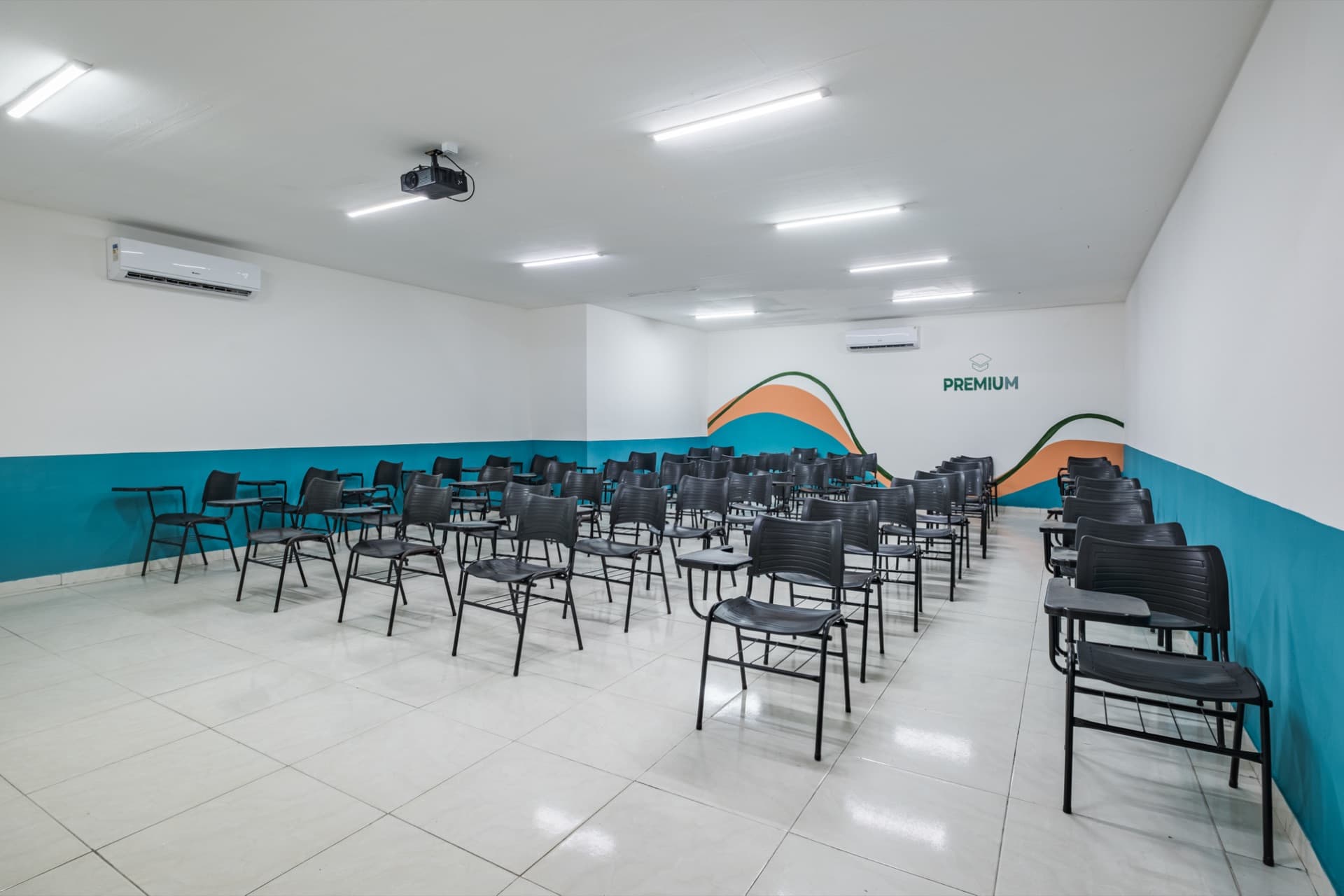 Auditório com projetor e cadeiras universitárias