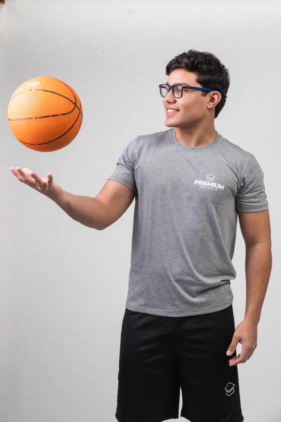 Aluno equilibrando uma bola de basquete com o uniforme esportivo do PREMIUM